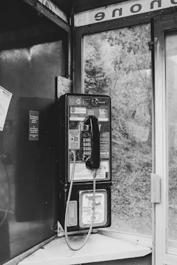 grayscale photography of telephone booth