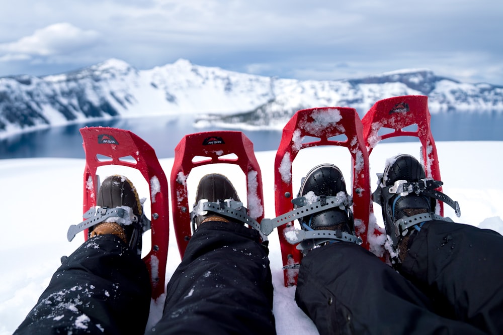 two persons wearing red snow shoes