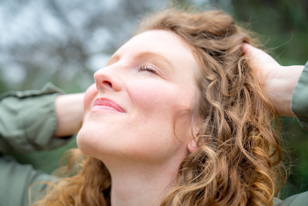 woman holding her hair while facing up