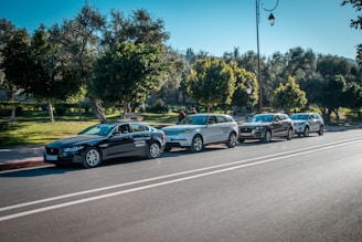 A group of vehicles parked outside a registration office under a clear blue sky.