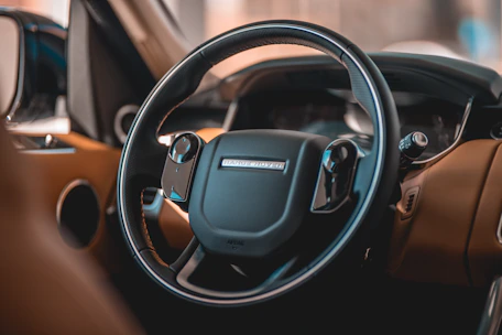 A close-up of premium car keys resting on a glossy dashboard inside a high-end imported vehicle.