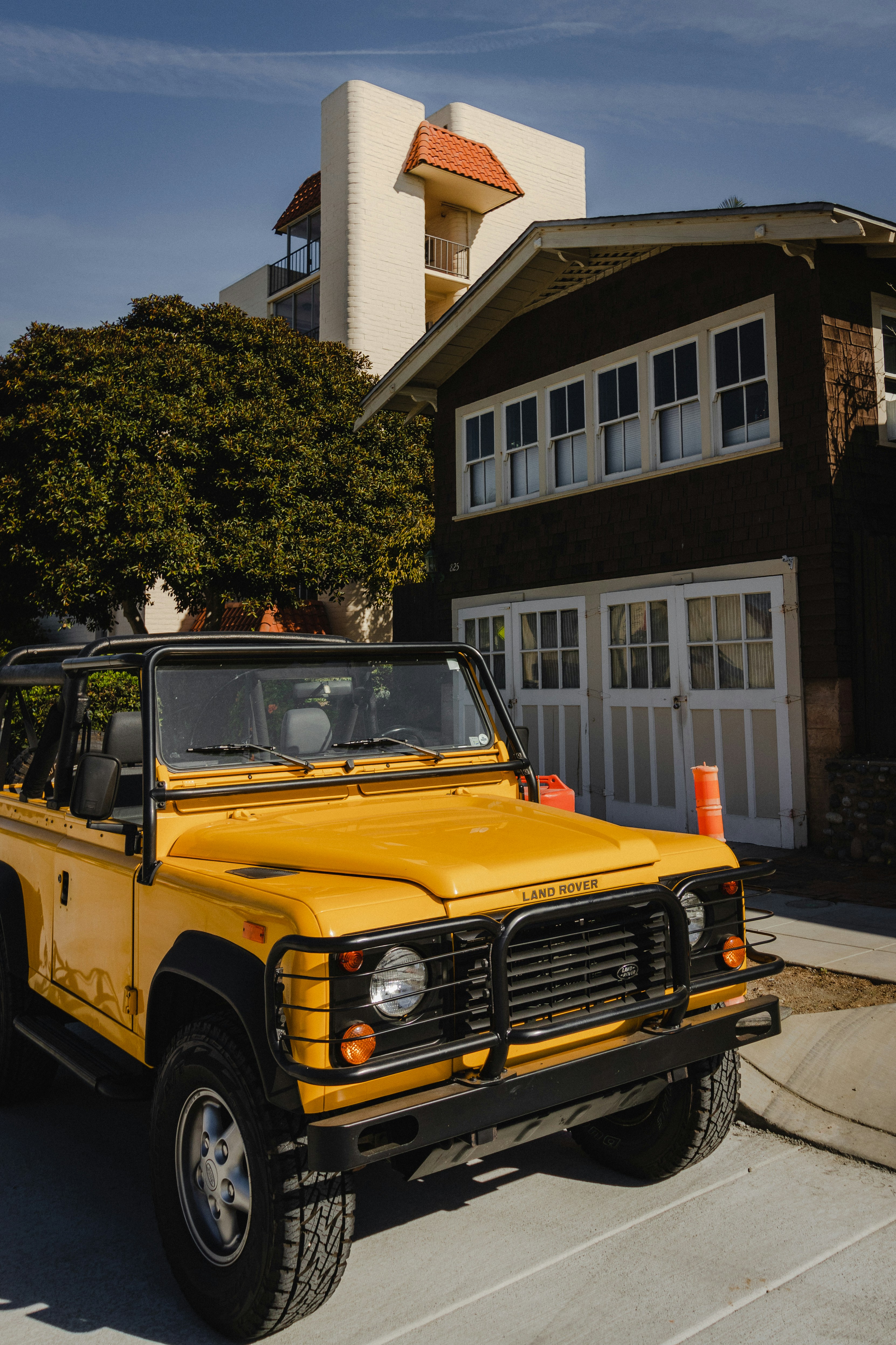 Veículo amarelo estacionado perto de árvore
