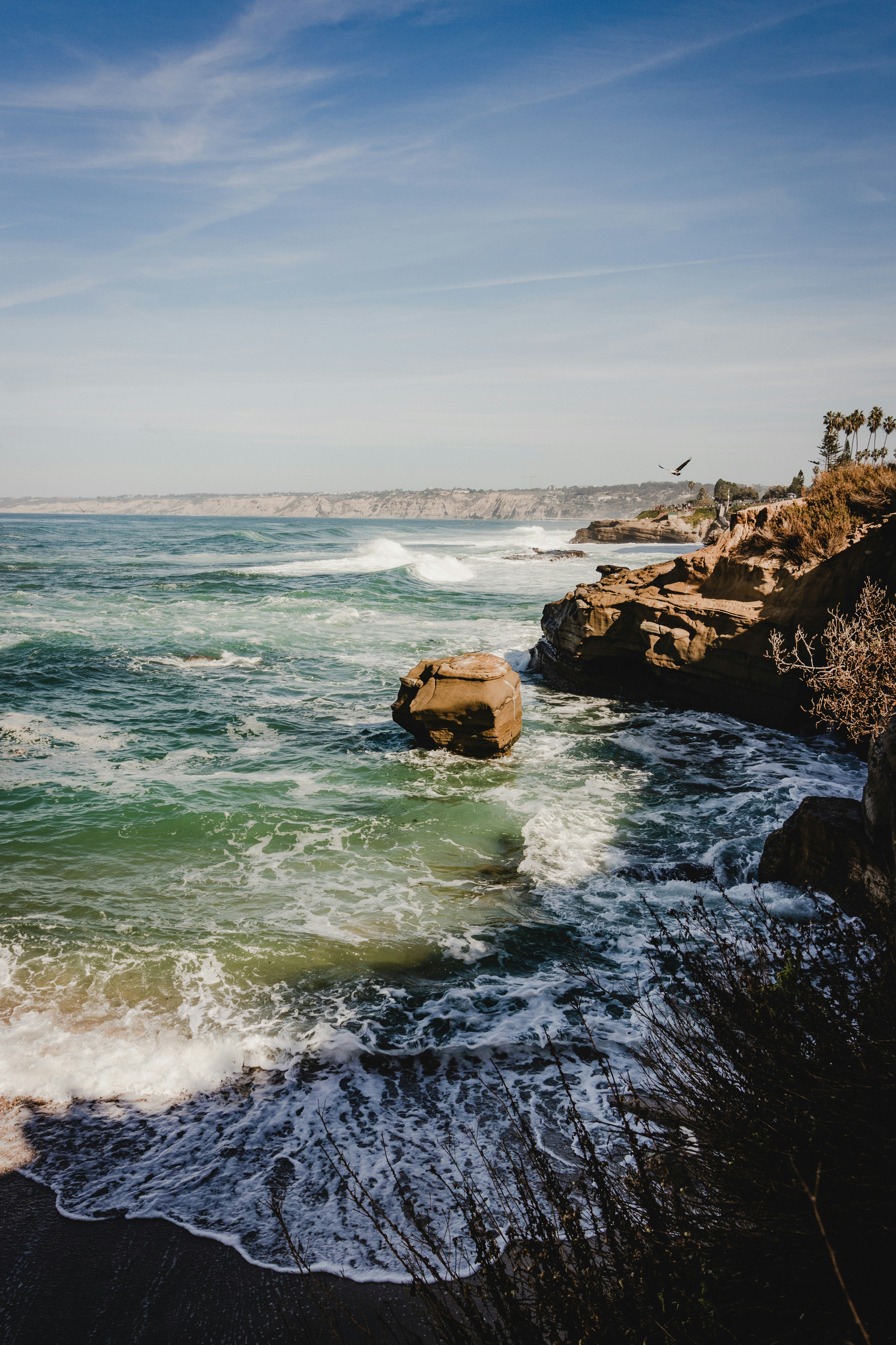nature photography of waves crashing rocky shore during daytime