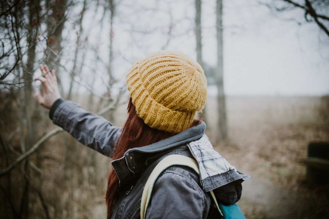 woman wearing yellow knit cap and gray jacket