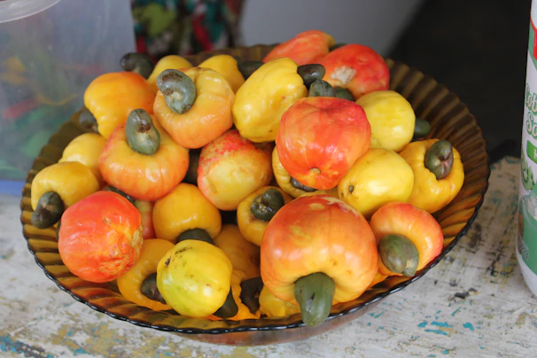 Golden cashew nuts freshly harvested, displayed on a woven basket with natural fibers.