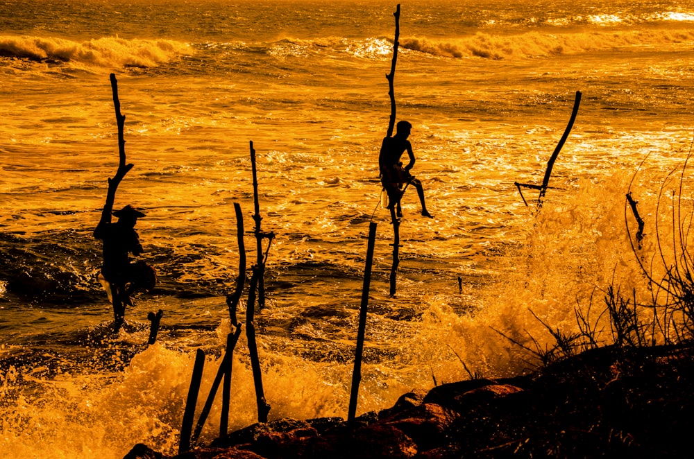 silhouette of two person near body of water