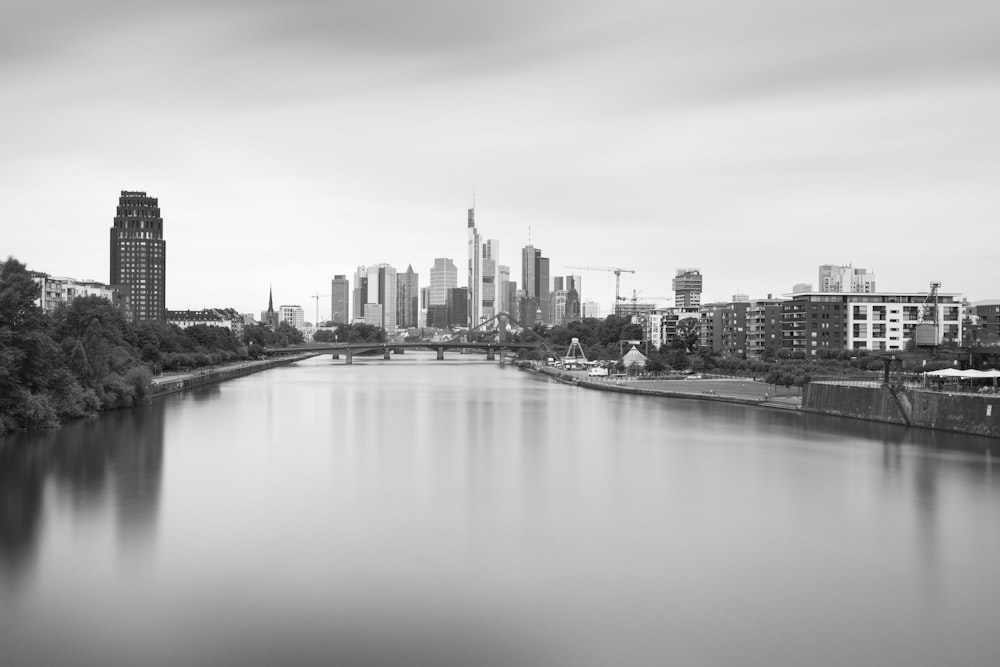 Foto en escala de grises de un cuerpo de agua cerca de edificios