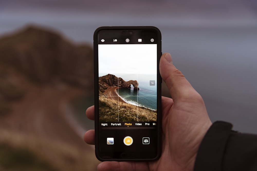 person taking photo of rock formation