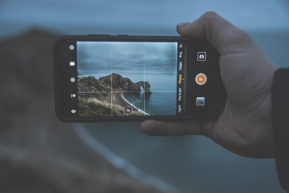 person taking photo of islet