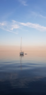 Sailboat on calm water at sunset, symbolizing peace and stress relief
