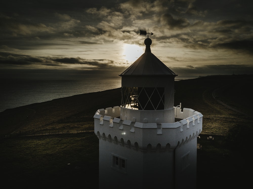 white concrete lighthouse during sunset