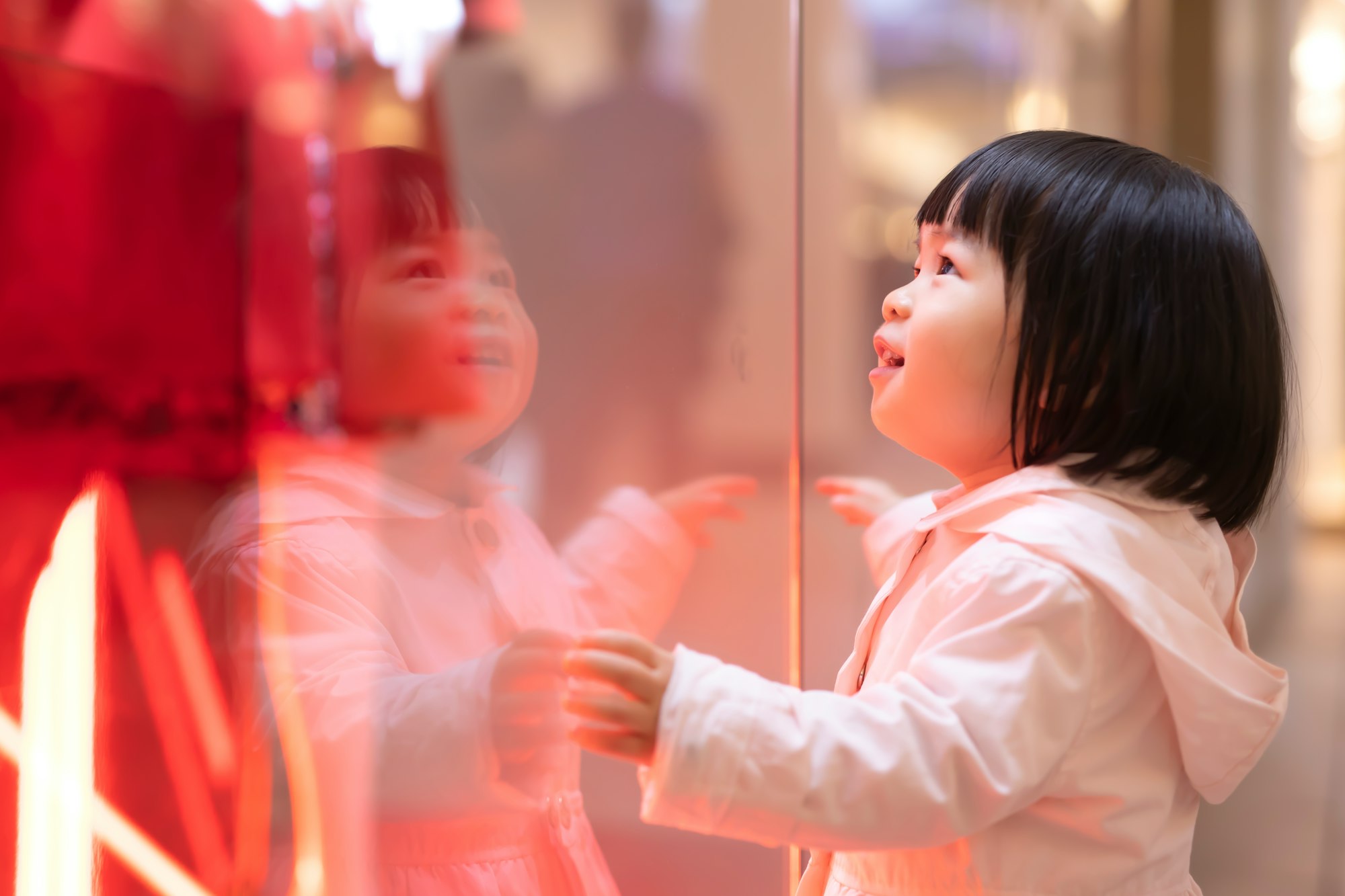 A child appreciating a holiday shopping window display during Black Friday.