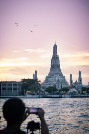 silhouette photo of man taking photo of concrete church