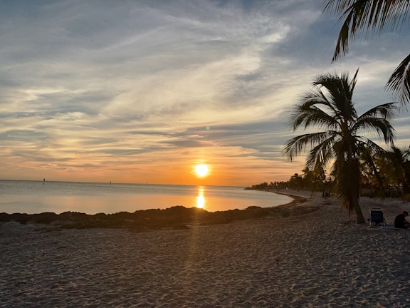 A serene sunset over the turquoise waters of Cancún beach with soft beige sands.