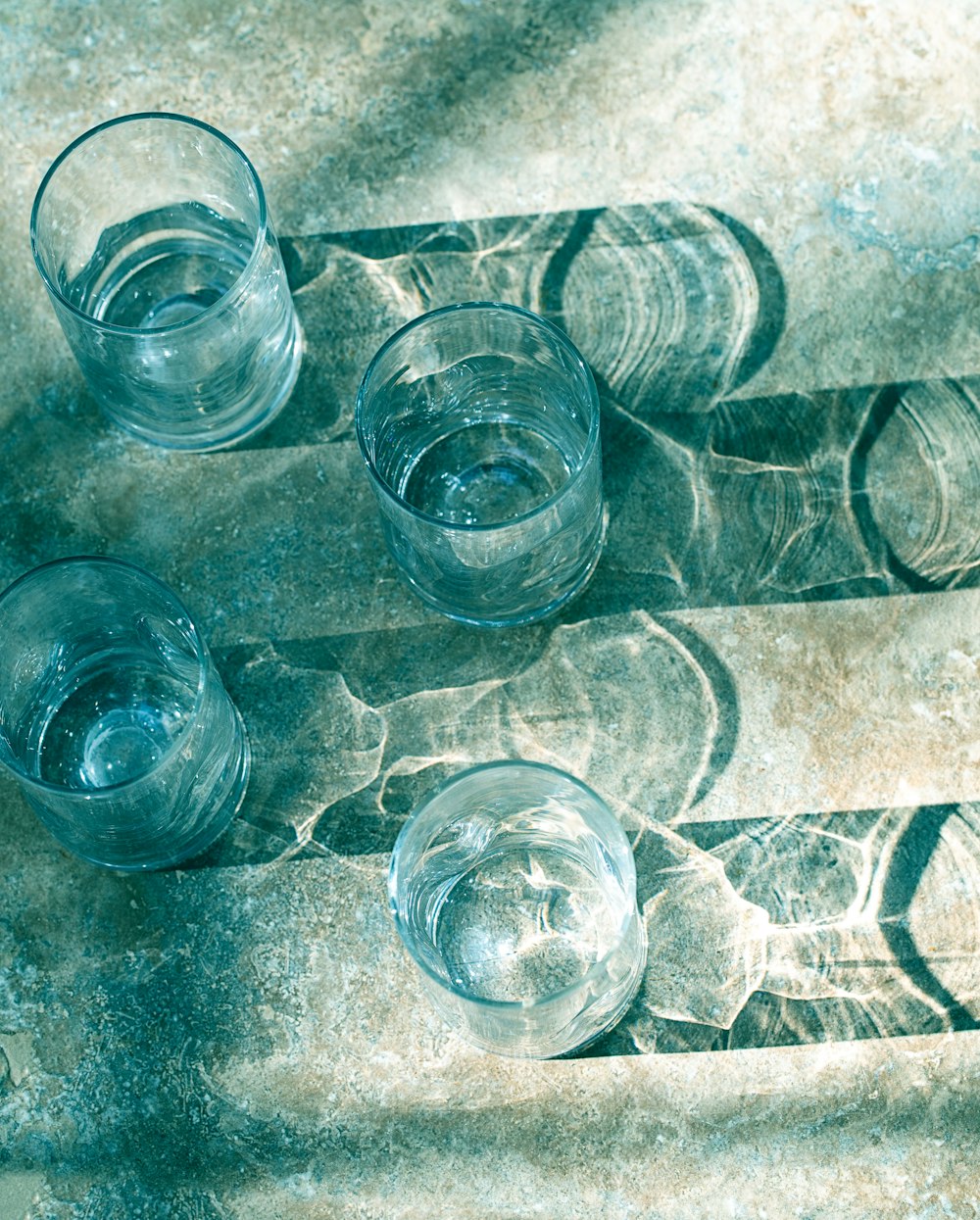four clear drinking glasses