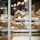 A bakery display with various pastries and breads, including croissants, chausson pommes, and pain choco. The items are neatly arranged in baskets with price tags, creating a warm and inviting atmosphere.
