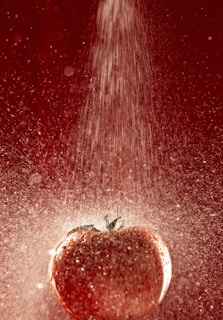 A vibrant splash of ripe tomatoes bursting against a rustic wooden background, symbolizing fresh and lively news.