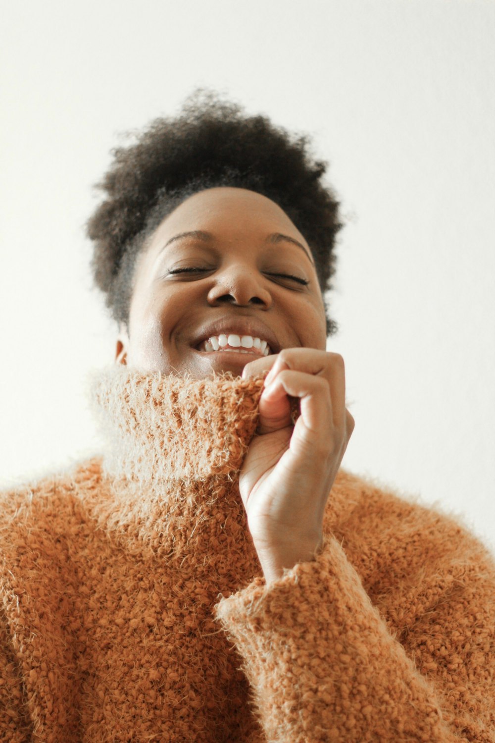 smiling woman in brown knit sweater