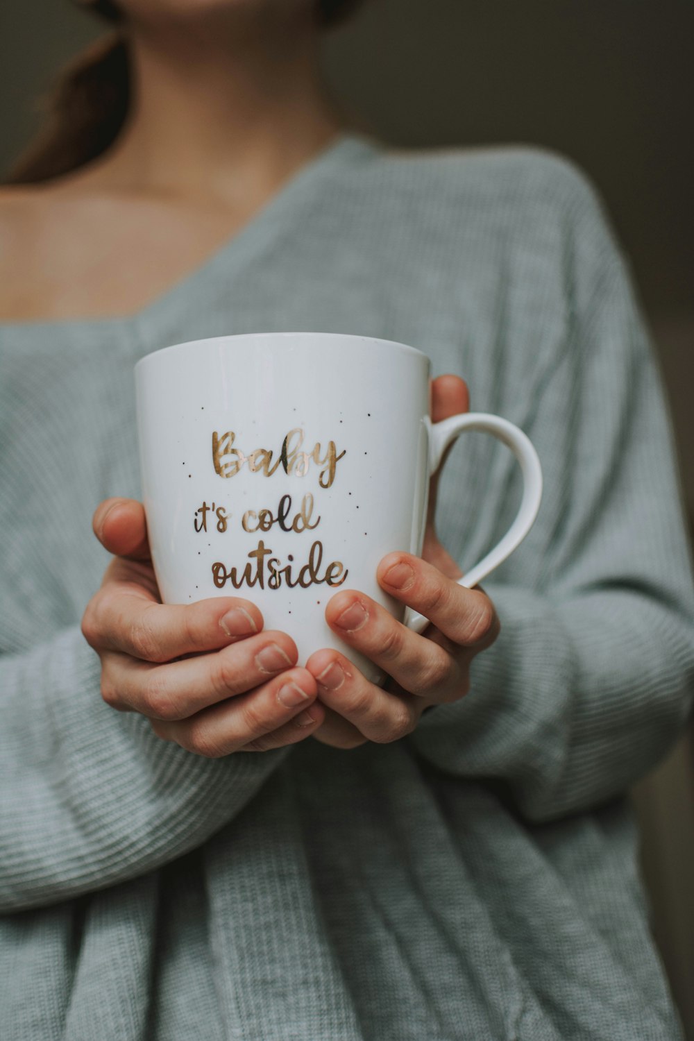 woman holding white ceramic mug