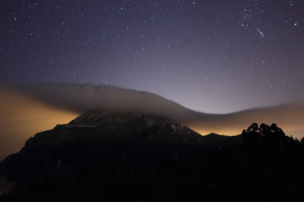 silhouette di montagna con cielo notturno chiaro