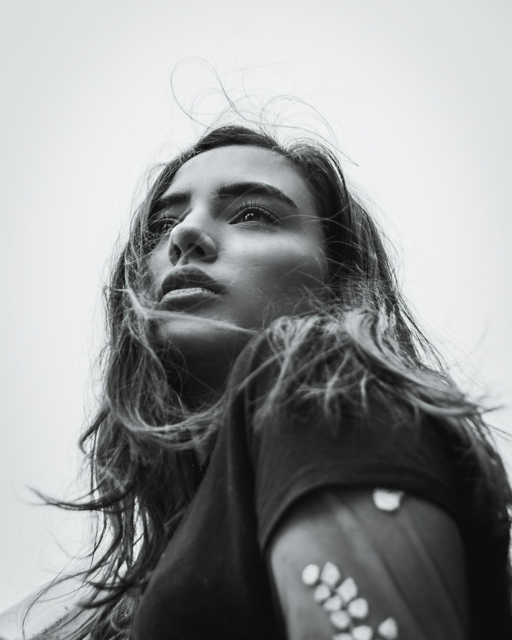 Photographie en niveaux de gris d’une femme avec des cheveux sur le visage