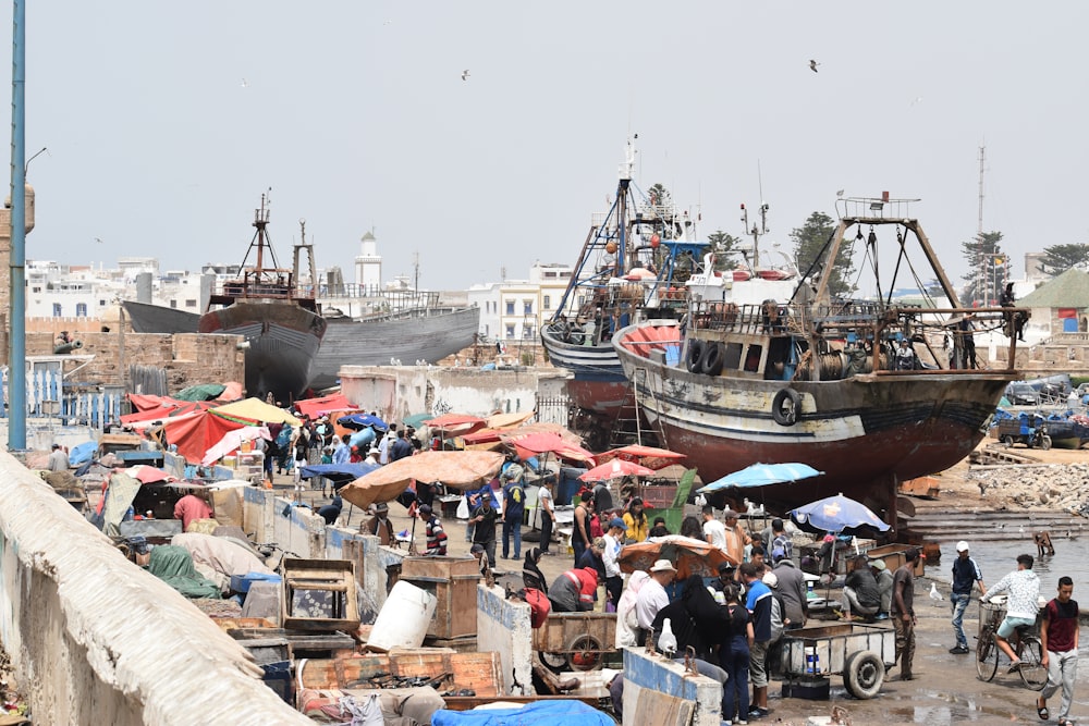 several ships near people during daytime