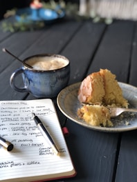 Close-up of a beautifully decorated cake with a laptop and marketing plans in the background.