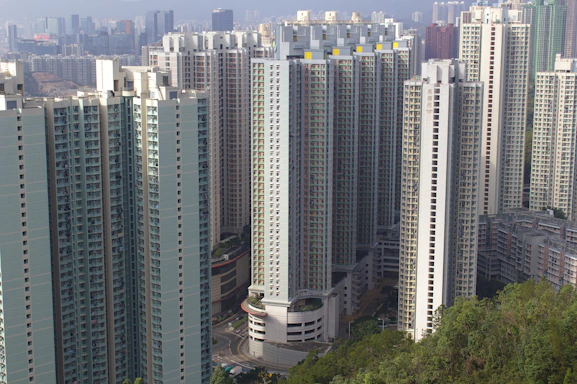 A modern high-rise residential buildings cluster in a green urban setting under a clear blue sky