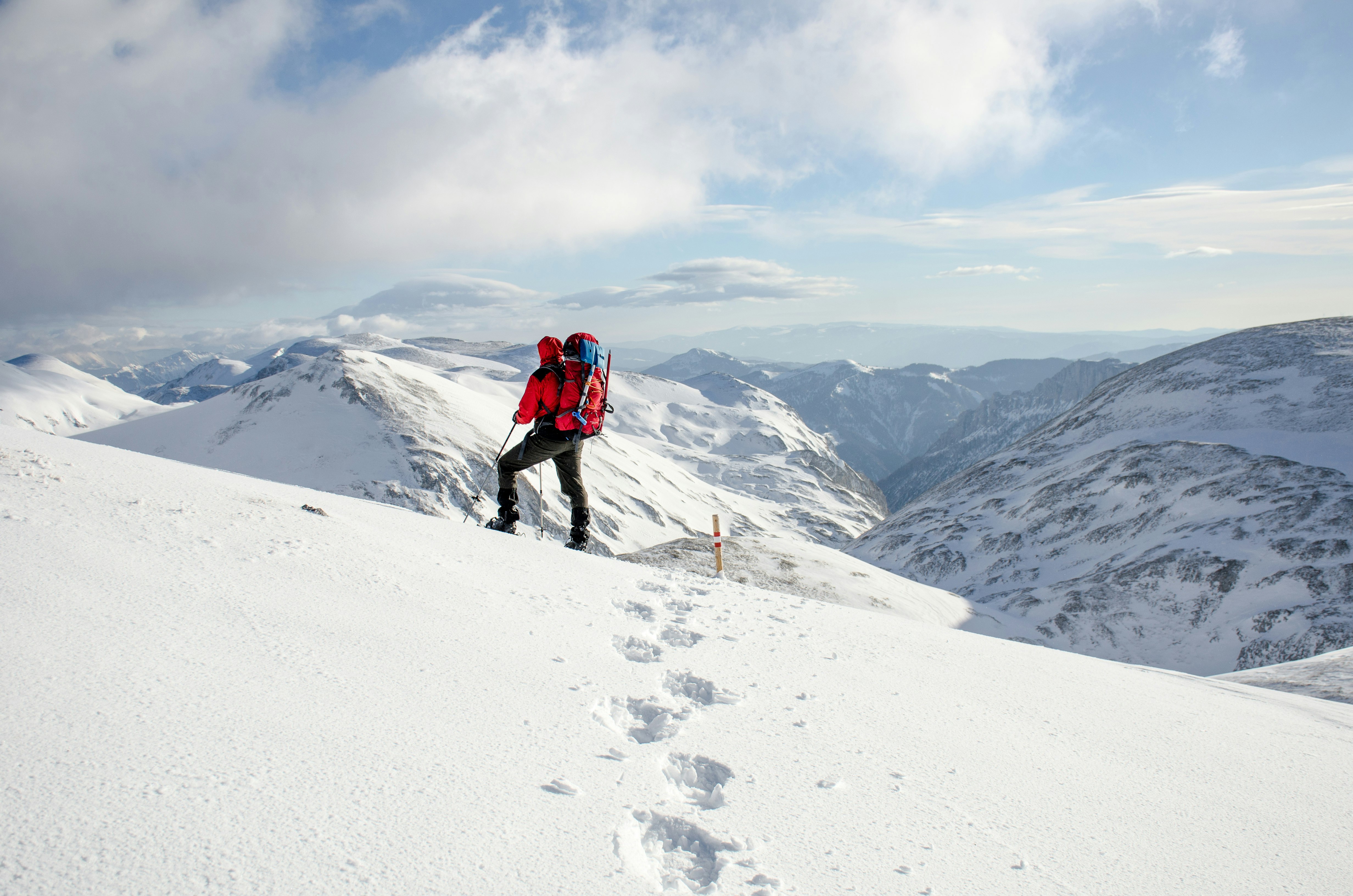person climbing on snow-covered mountain