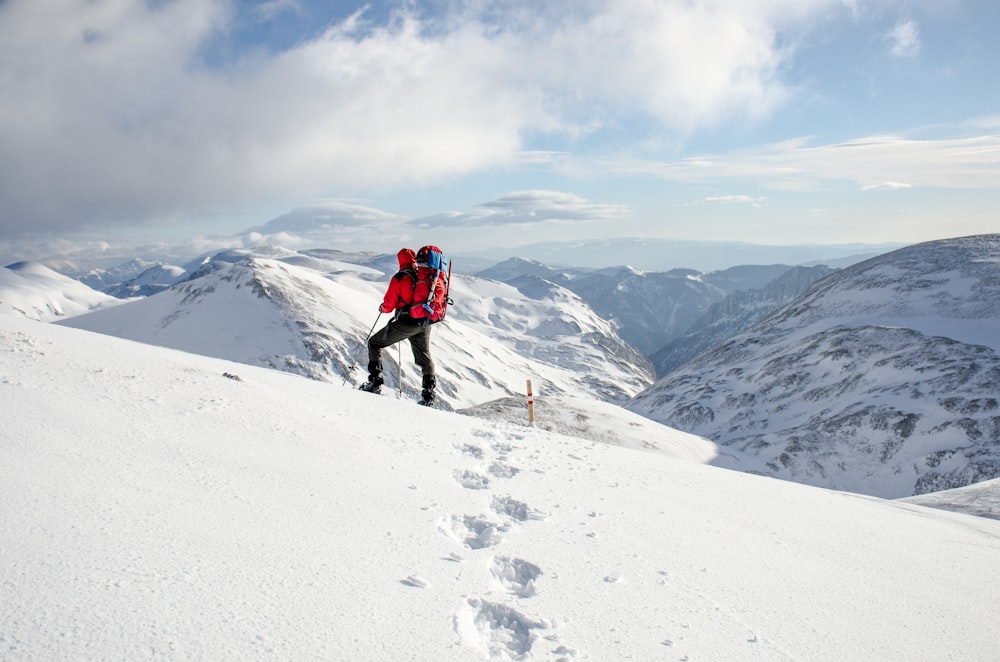 person climbing on snow-covered mountain
