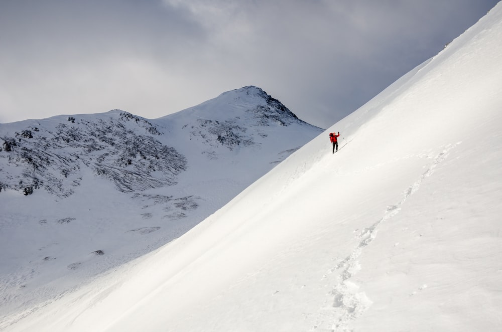 a person walking up the side of a snow covered mountain