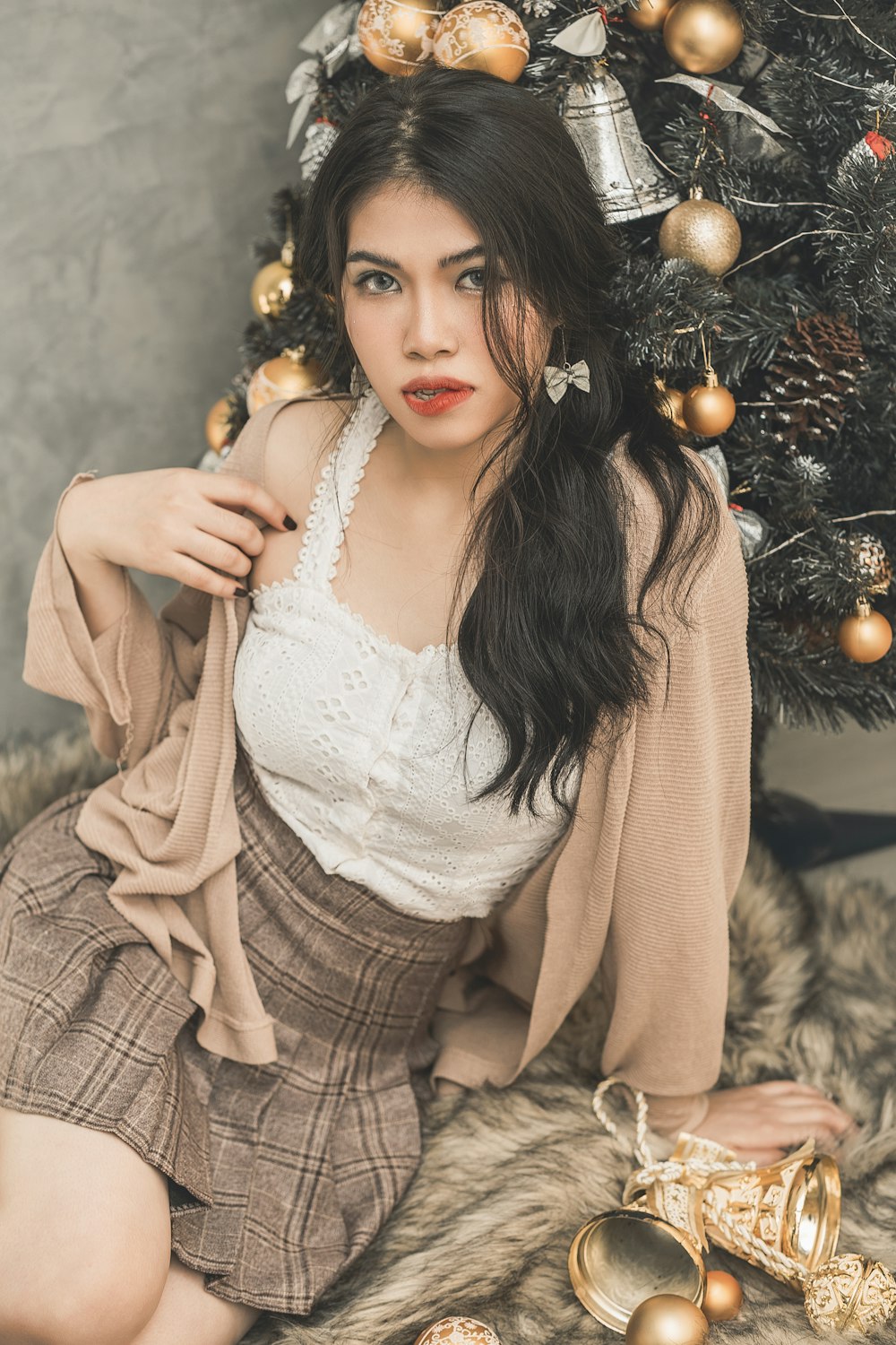 woman sitting beside Christmas tree