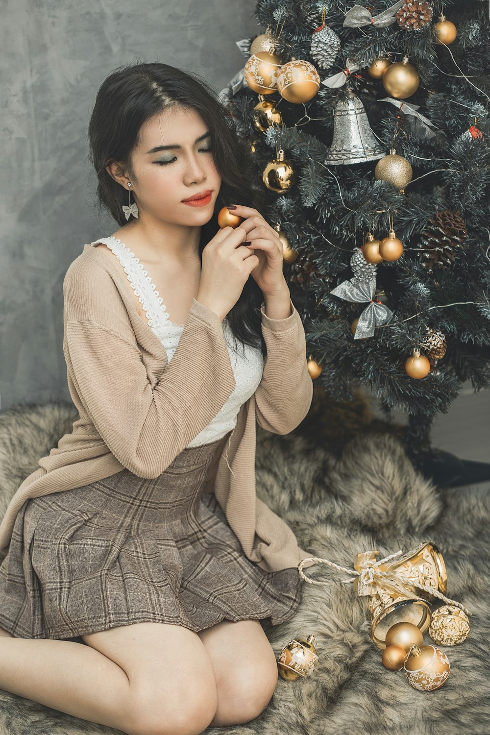 woman sitting beside Christmas tree