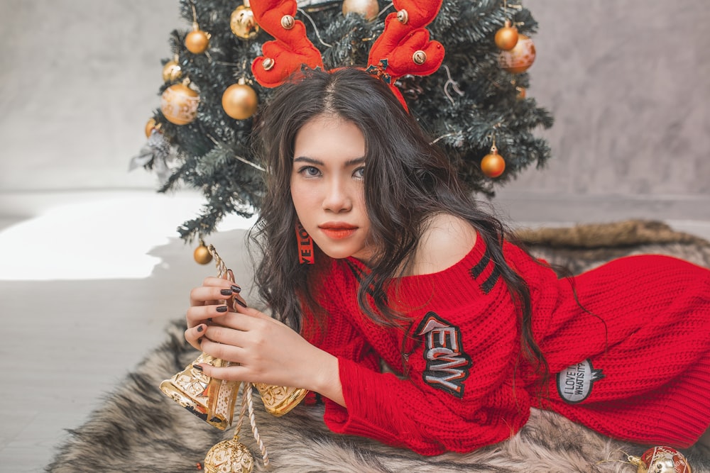 woman lying on fur cloth near Christmas tree