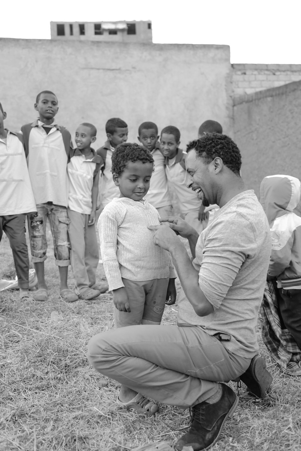 grayscale photography of man tickling child