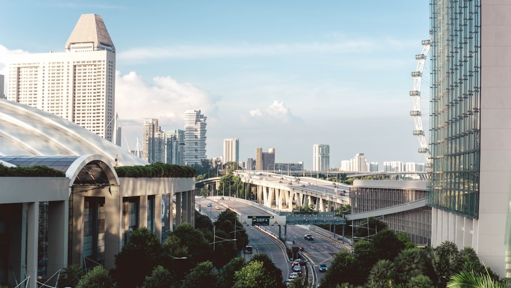 vehicles traveling on road near high rise buildings during daytime