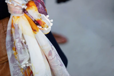 Close-up of a smooth, shiny silk scarf draped elegantly on a wooden table