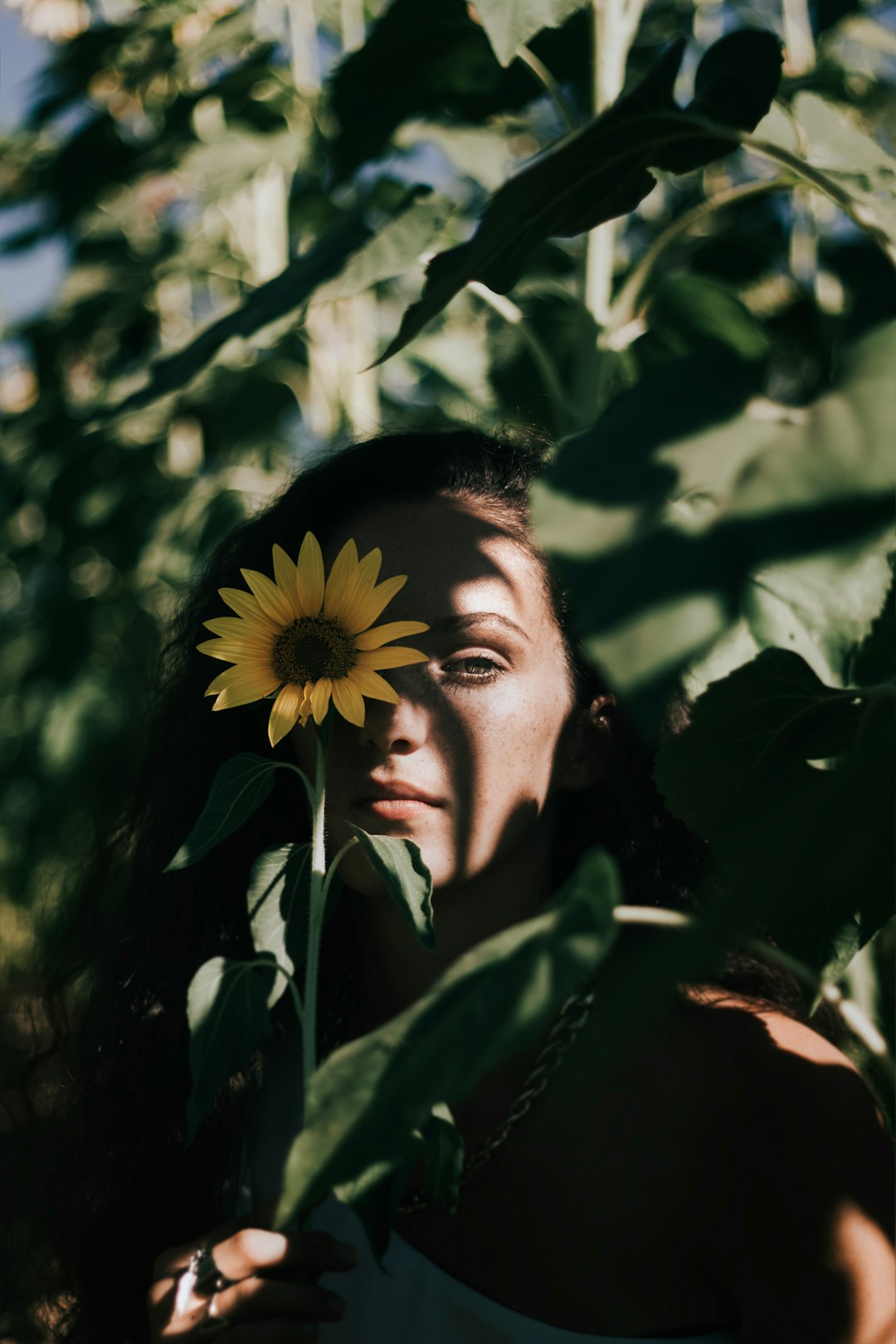 woman covering her right eye with Sunflower