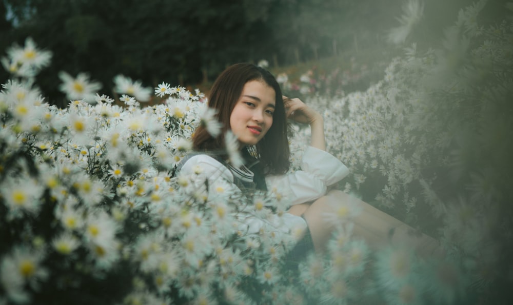 woman sitting on flowers field