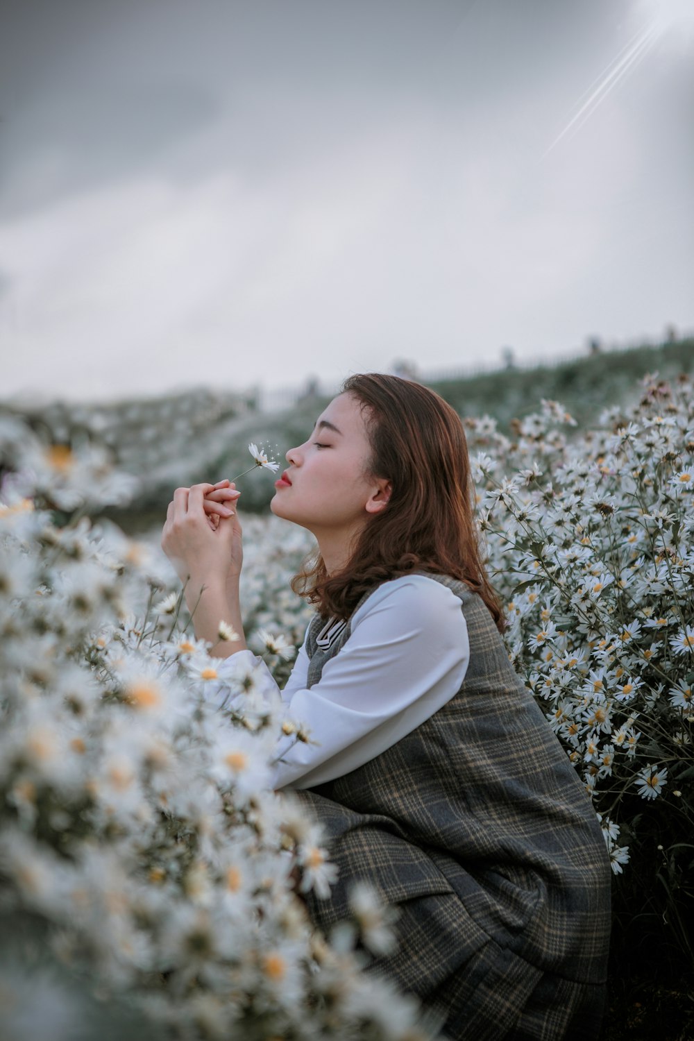 selective focus photography of woman smelling flower