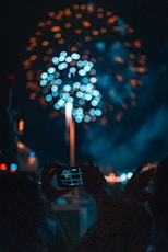 person taking picture of fireworks