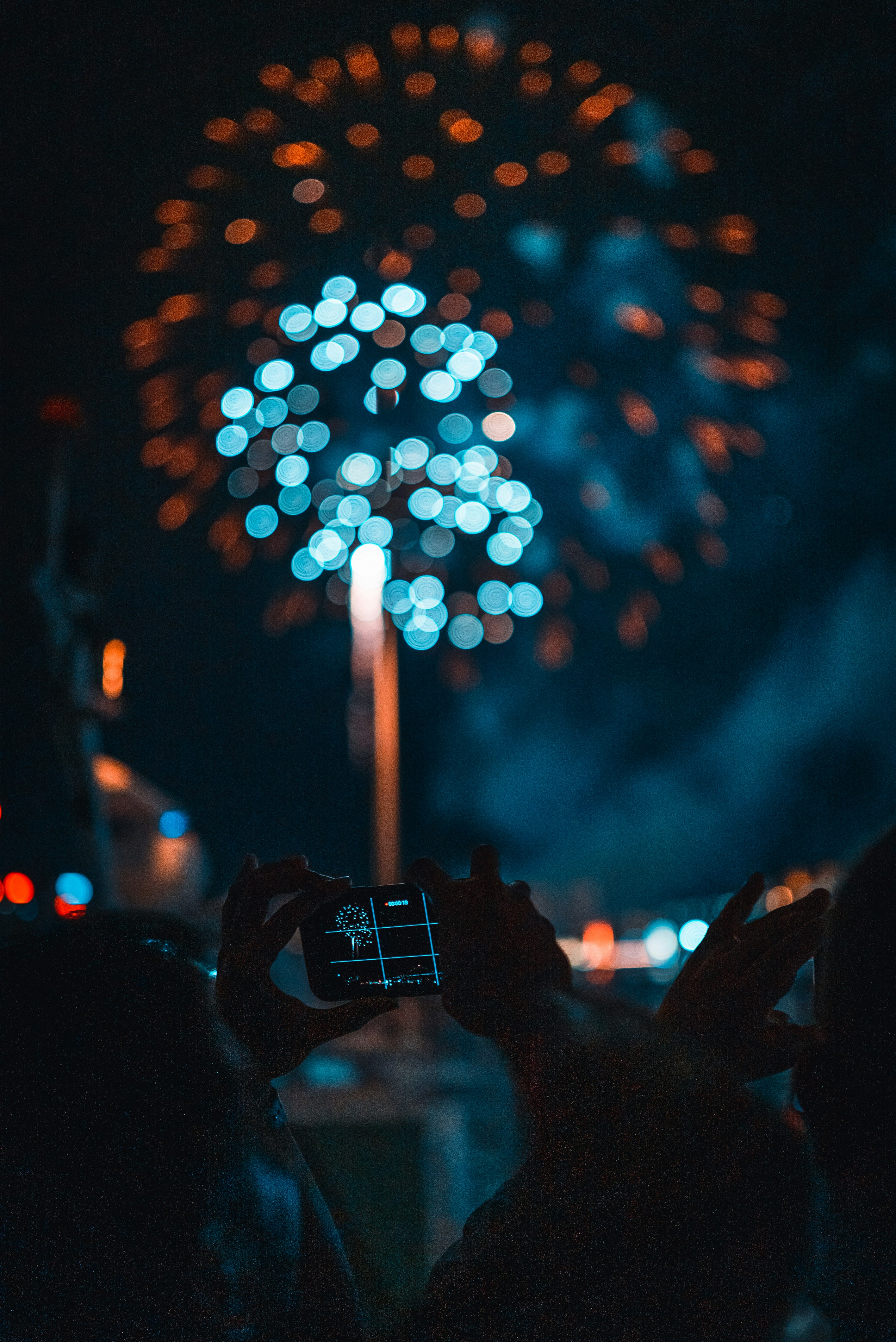 person taking picture of fireworks