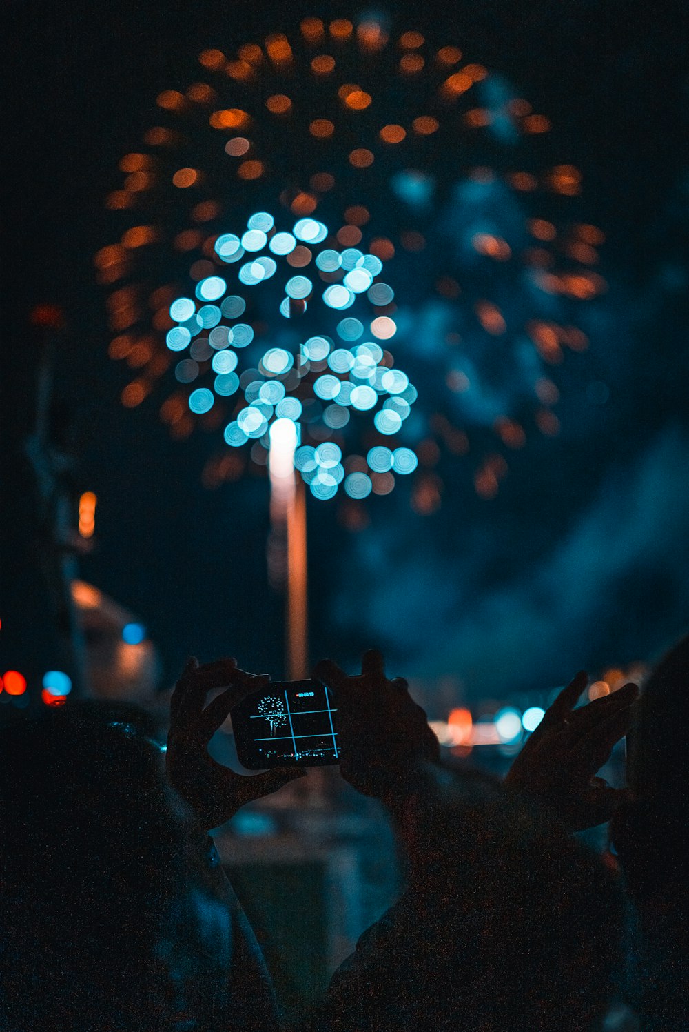 person taking picture of fireworks