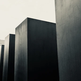 A quiet memorial site in Berlin, showing weathered stone markers and a somber sky.