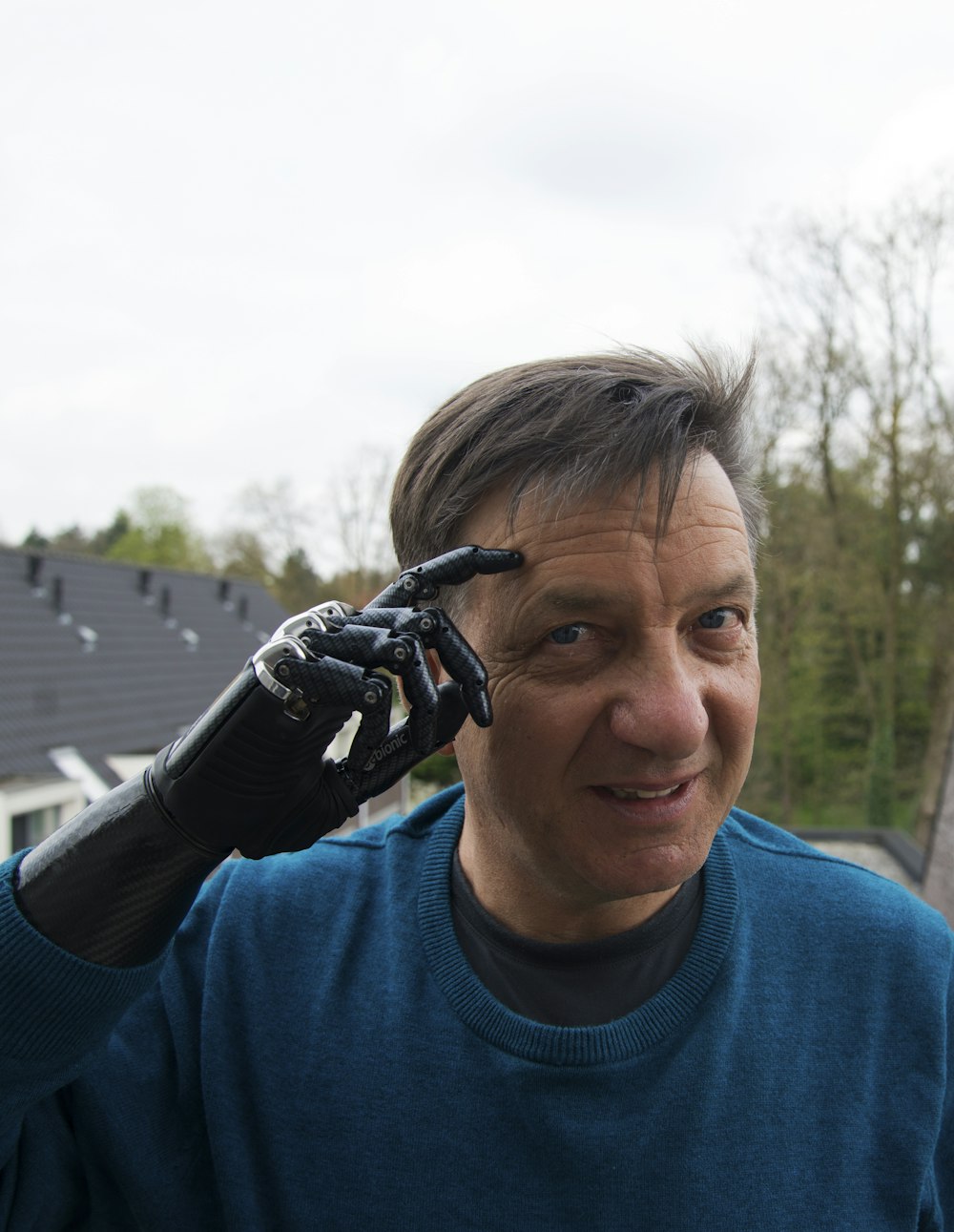 man with black robotic hands smiling