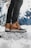 A close-up of stylish winter boots on a snowy background.