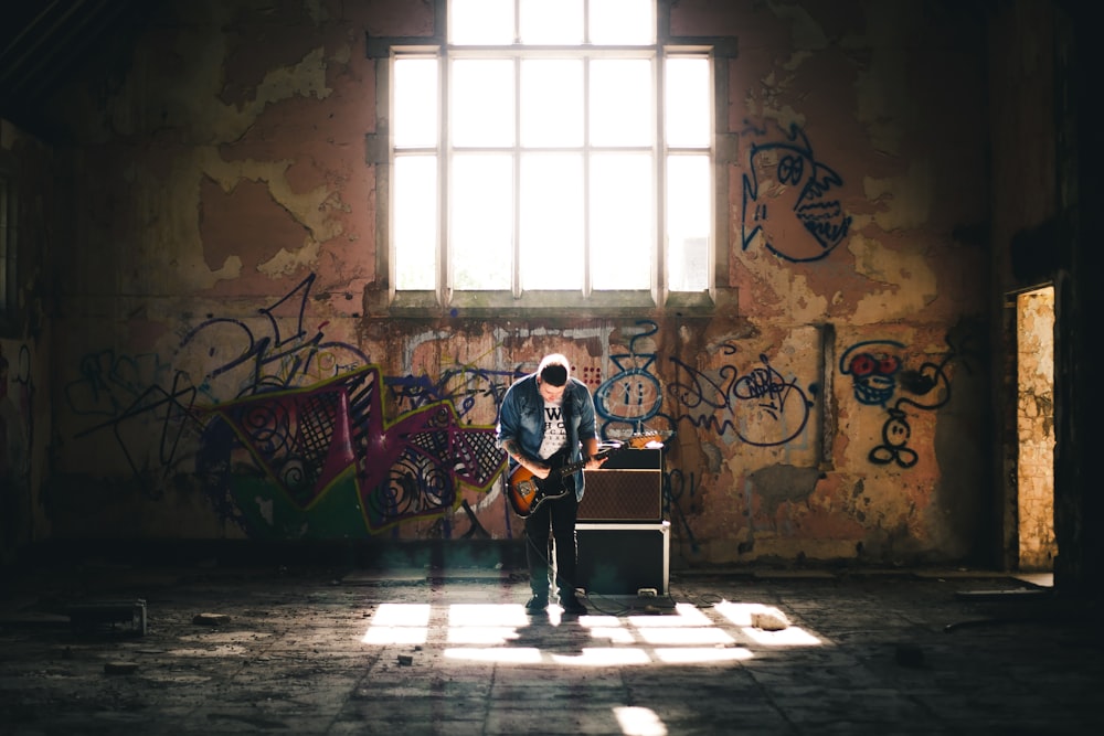 man playing guitar inside building