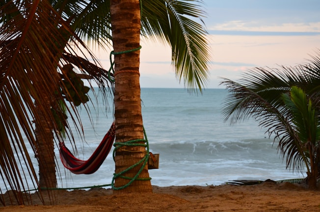 Sunset over a beachfront resort with hammocks swaying gently in the warm breeze.