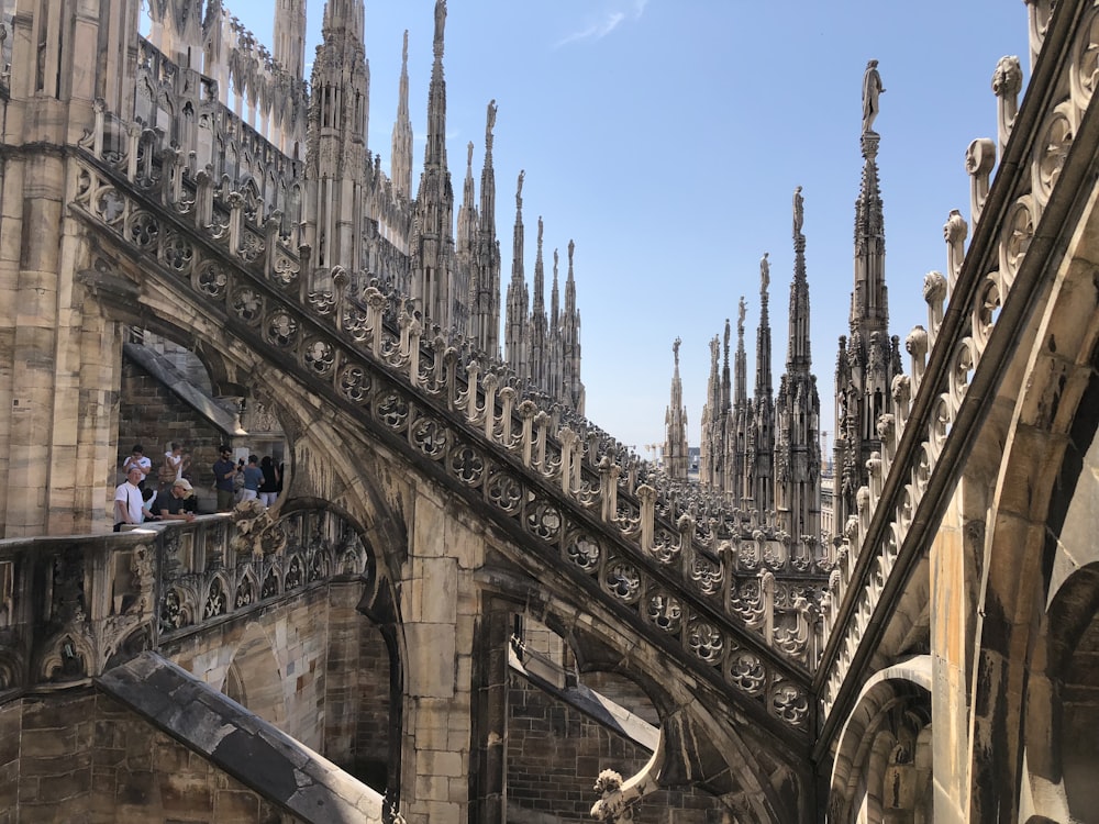 Persone in piedi sull'edificio in cemento marrone durante il giorno