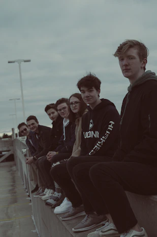 Group of diverse friends rocking navycrew streetwear, laughing and hanging out on a city rooftop at sunset.